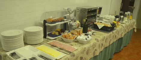 Una mesa de buffet con diversos alimentos y utensilios.