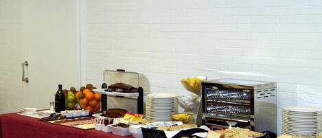 A buffet table with various food items and a refrigerator displaying a cityscape view.