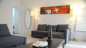 Ein modernes Wohnzimmer mit einem grauen Sofa, einem Couchtisch mit Dekoration und einem Bild an der Wand.