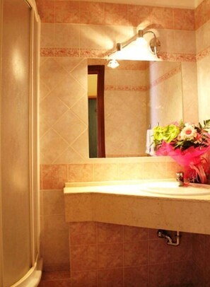 A bathroom with a mirror, a sink, and a shower. - Albergo Aurora (Castenaso)