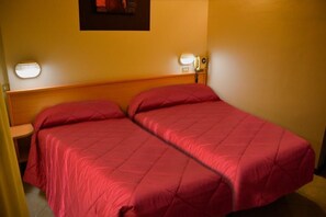 A hotel room with two beds, each with a red bedspread, a wooden headboard, and bedside lamps. - Albergo Aurora (Castenaso)