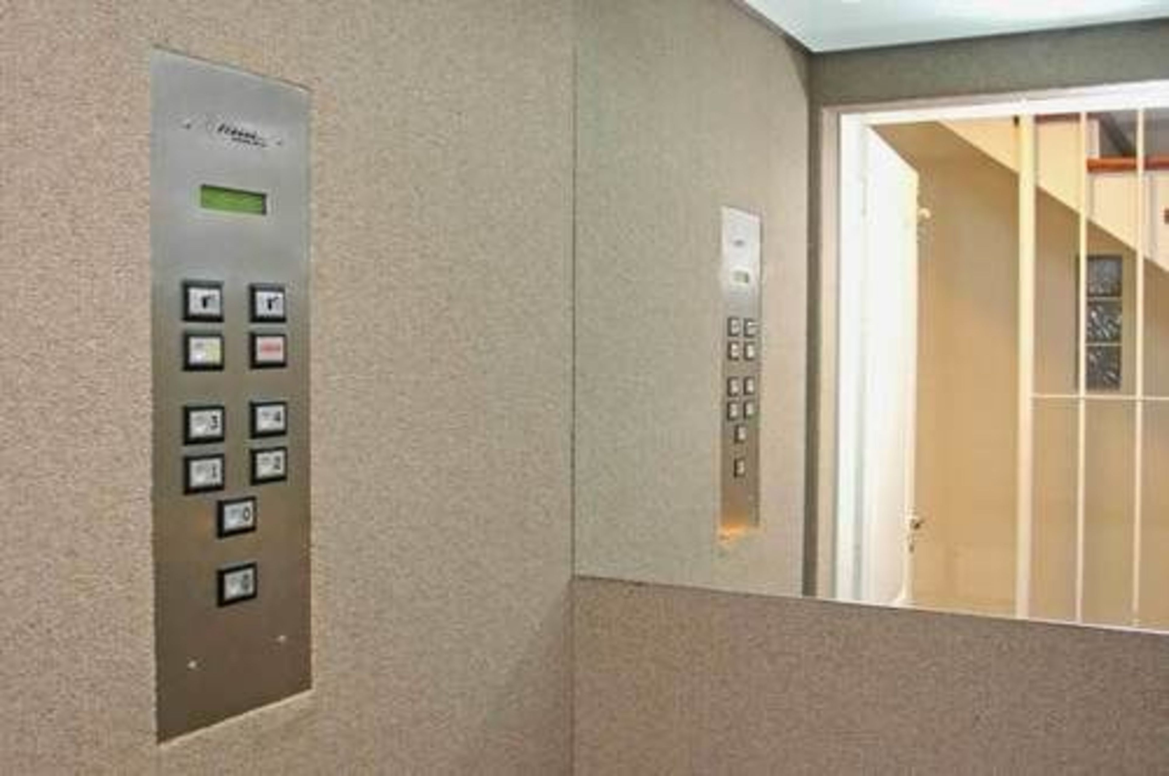 An elevator control panel with buttons and a digital display.
