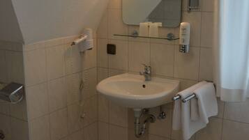 A bathroom with a sink, mirror, towel rack, and a hairdryer.