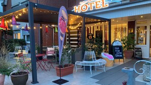 A hotel exterior with outdoor seating, a sign reading "Oyten am Markt HOTEL", and a menu board outside. - Hotel Oyten am Markt (Oyten)