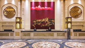 A lobby with a large abstract painting, two receptionists, and a marble floor with geometric patterns. - Intercontinental Resort Lhasa Paradise by IHG (Lhasa)