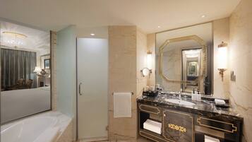 Un baño moderno con un espejo grande, una bañera y un tocador con encimera de mármol.