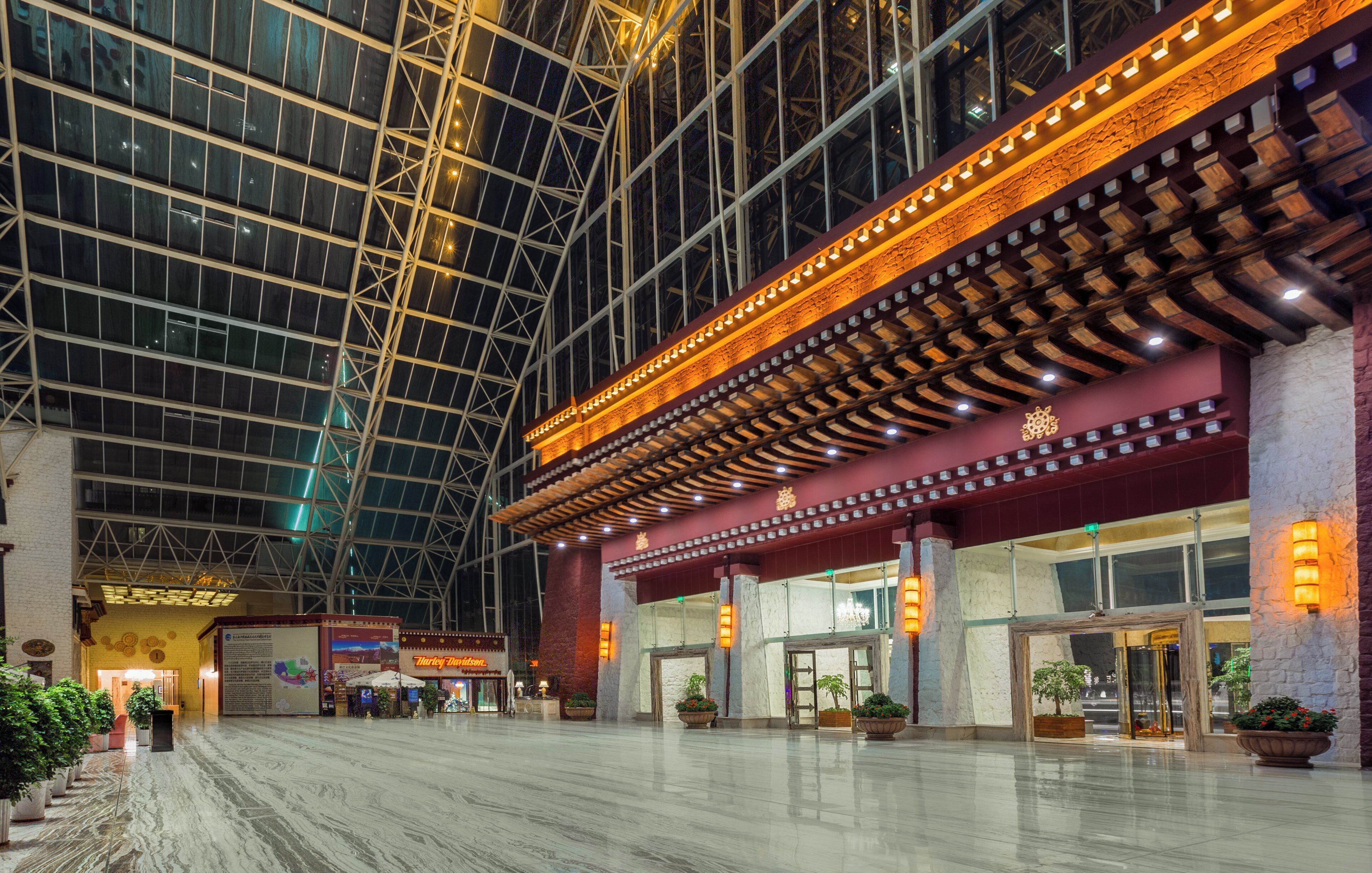 A spacious lobby with a high ceiling and large windows, featuring a traditional architectural style with wooden beams and stone accents.