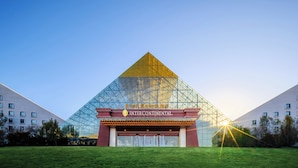 A large glass pyramid structure with a sign reading "INTERCONTINENTAL" in front of a modern building. - Intercontinental Resort Lhasa Paradise by IHG (Lhasa)