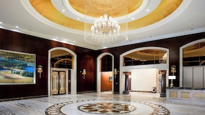 A grand lobby with a large chandelier, marble flooring, and a painting on the wall. - Intercontinental Resort Lhasa Paradise by IHG (Lhasa)