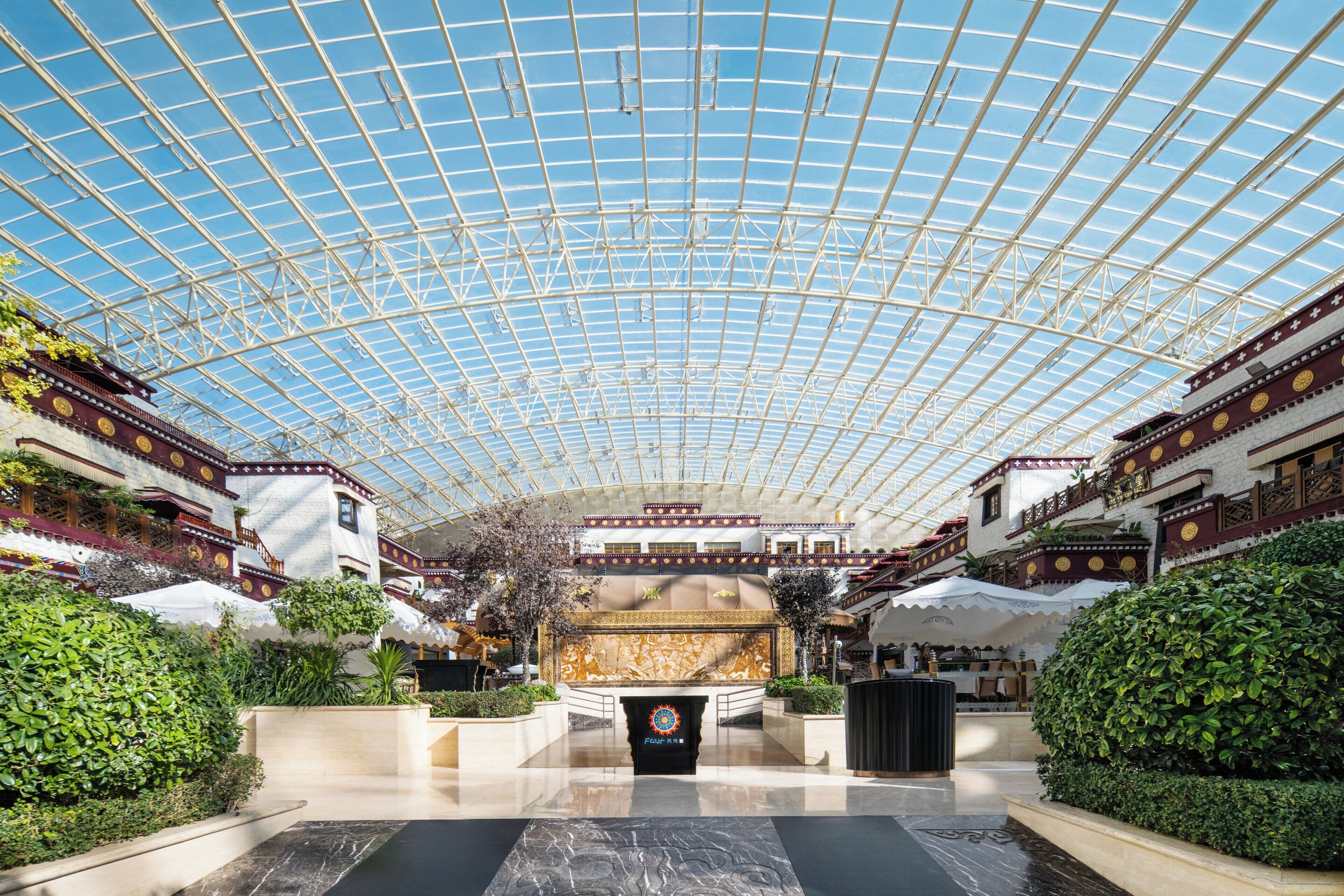 A spacious atrium with a high glass ceiling, a central fountain, and traditional architectural elements.