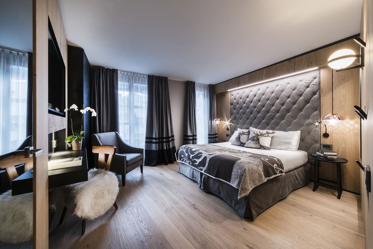 Een moderne hotelkamer met een groot bed, een bureau en een stoel.