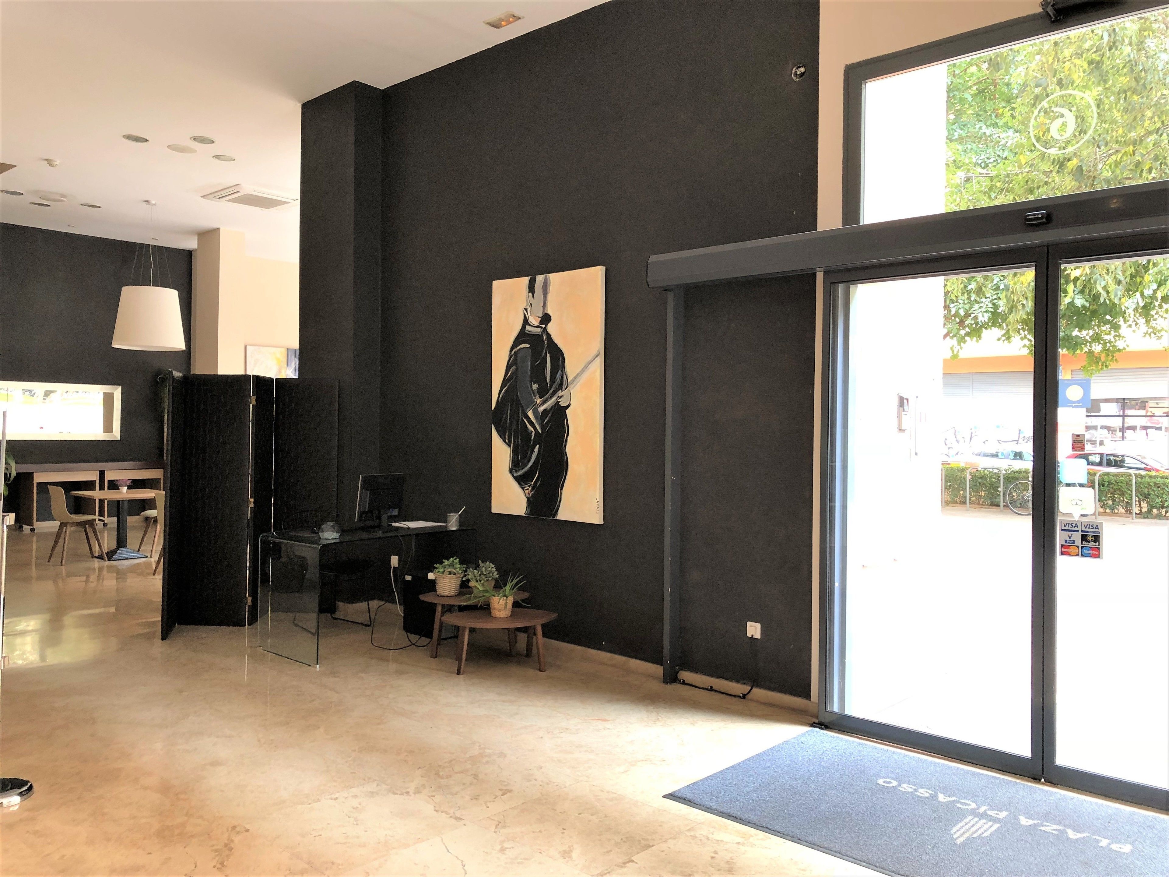 A modern interior with a black wall, a large window, and a door leading outside.