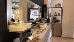 Een bakkerij toonbank met brood, gebak en een broodsnijmachine.