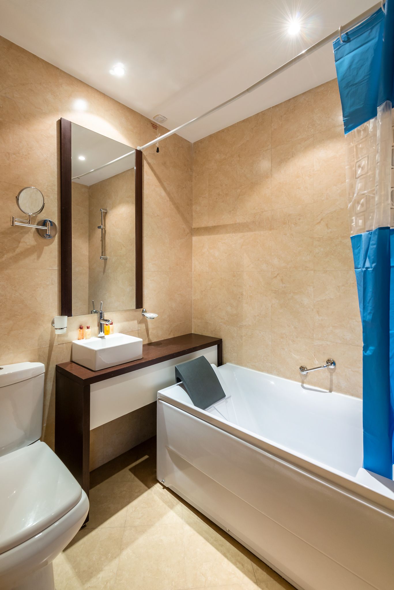 Un baño moderno con lavamanos, espejo y bañera blancos.