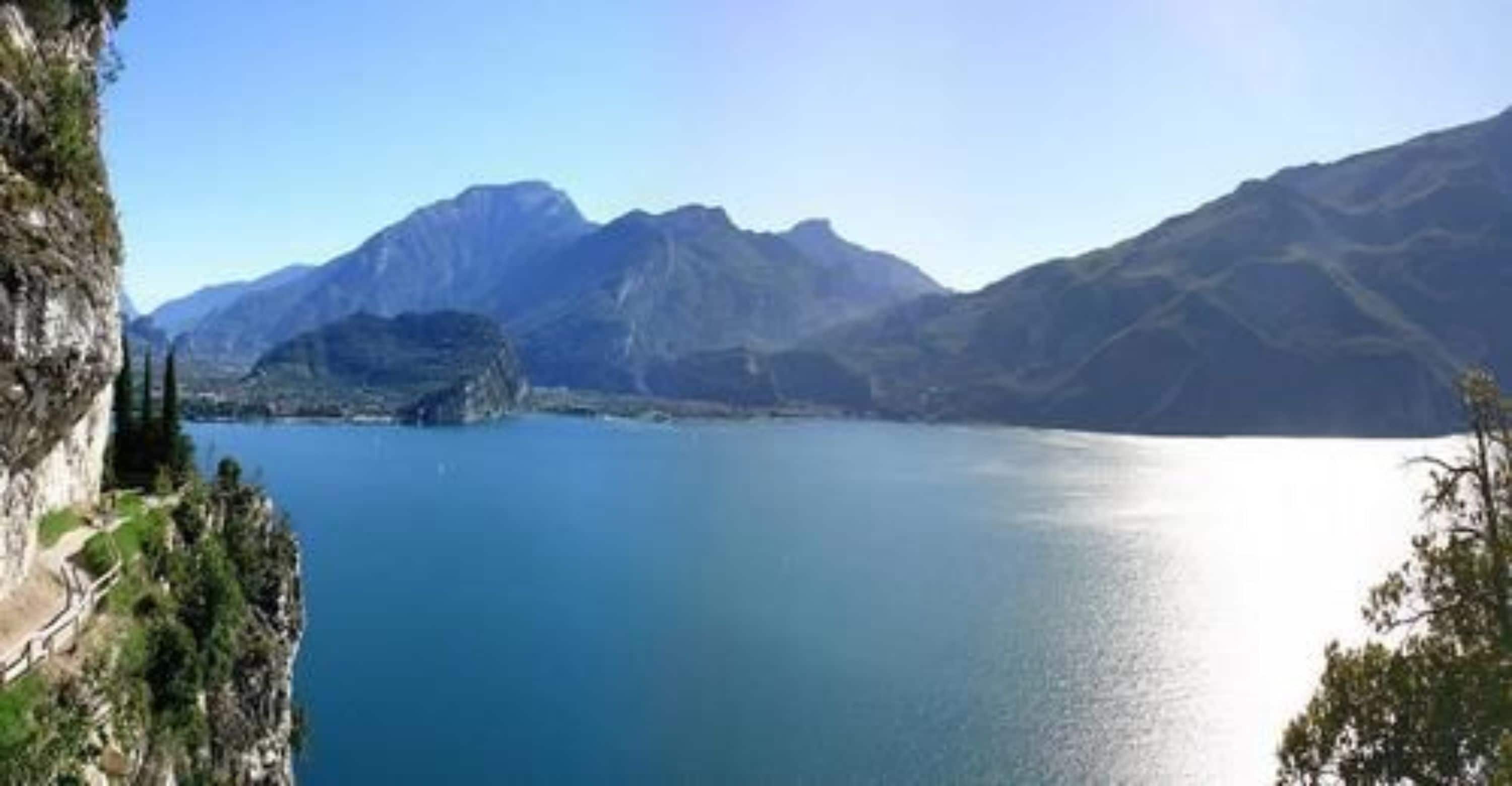 Un paysage montagneux avec un lac aux eaux limpides et une falaise rocheuse.