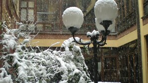 A snow-covered courtyard with a street lamp and a building with large windows and balconies. - Le Mura (Città di Castello)