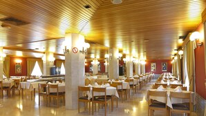 A spacious dining area with multiple tables and chairs, wooden ceiling, and warm lighting. - Domus Pacis Fatima Hotel (Ourem)