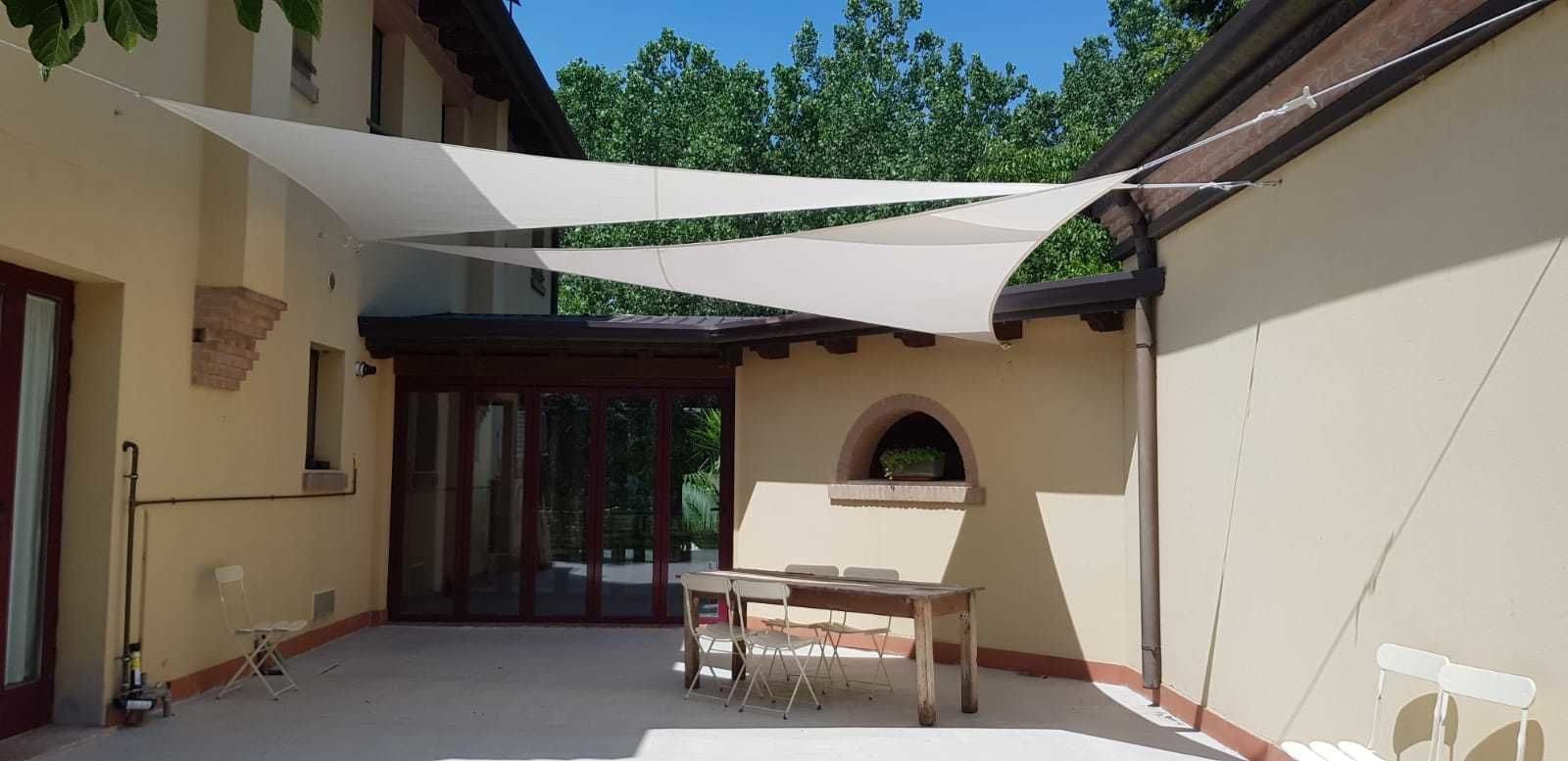 Un patio cubierto con una mesa y sillas, una ventana y un pequeño arco.