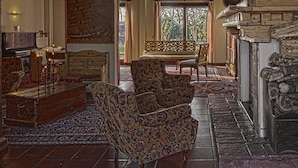 A traditional interior with wooden beams, patterned furniture, and a fireplace. - Villa Belfiore (Ostellato)