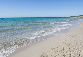 Una playa cerca, sillas reclinables de playa, sombrillas