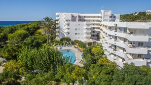 A modern hotel with multiple balconies, a swimming pool, and lush greenery. - Hamilton Court  Apartamentos (Es Migjorn Gran)
