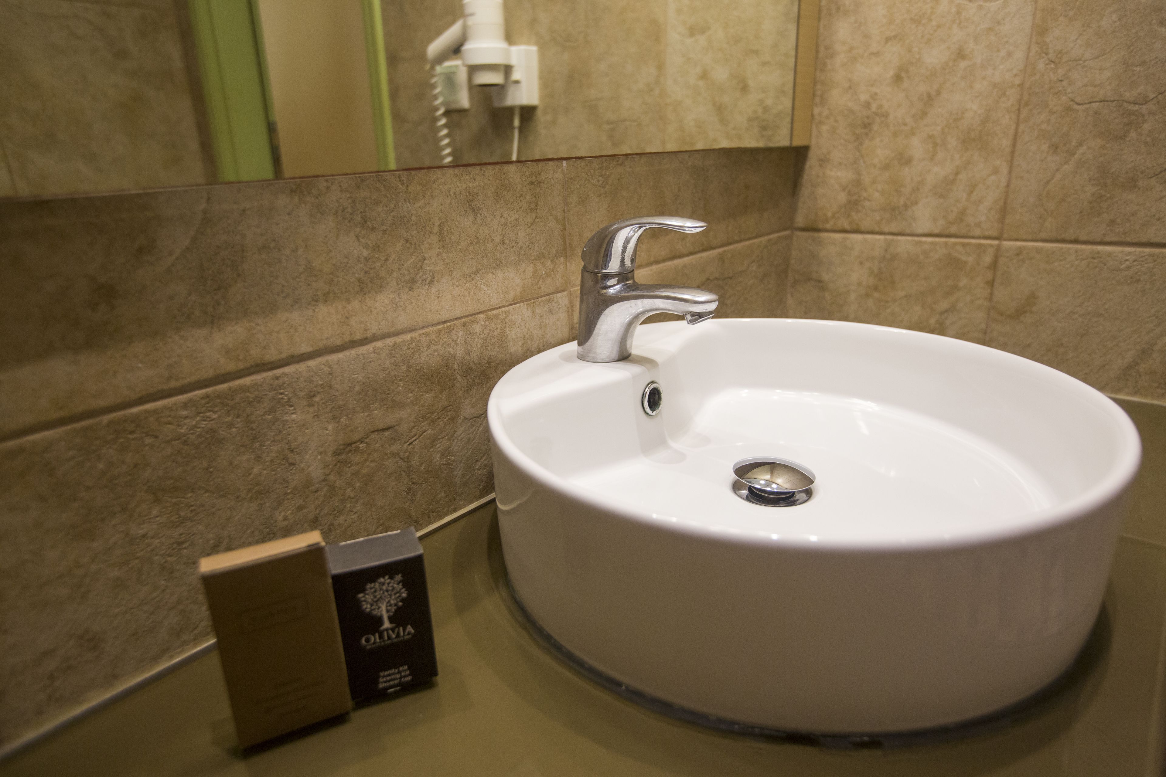 A bathroom with a white sink, a mirror, and a towel rack.