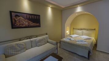 A hotel room with a sofa, a bed, and a painting on the wall.
