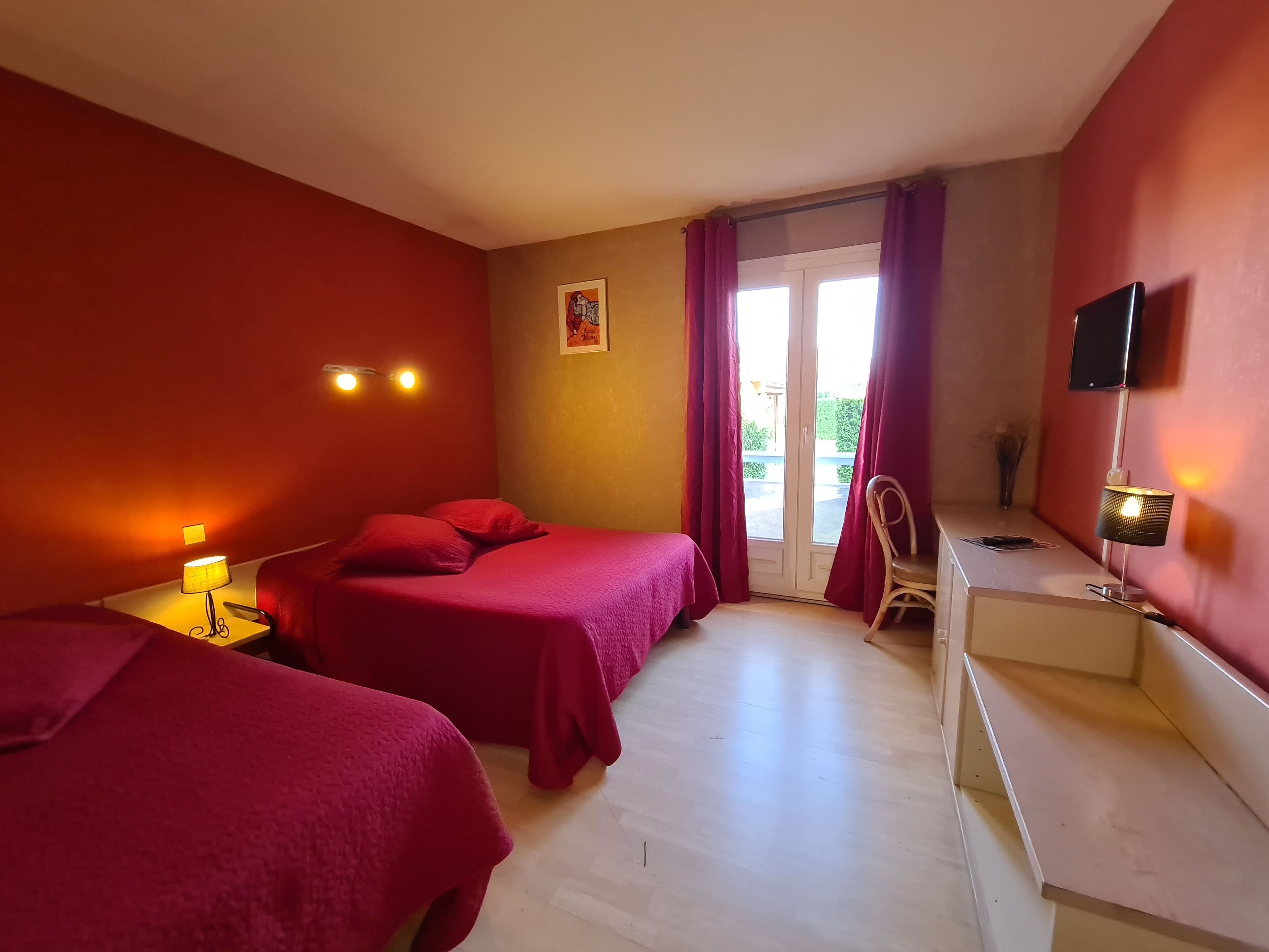 Hotelkamer met twee bedden, een bureau, een stoel, een televisie en een raam met gordijnen.