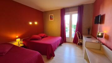 Hotelkamer met twee bedden, een bureau, een stoel, een televisie en een raam met gordijnen.