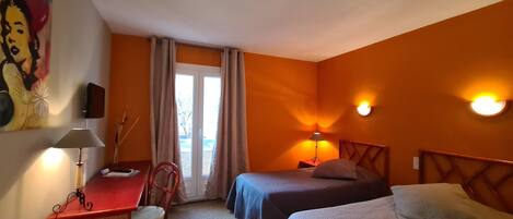 Habitación de hotel con dos camas, un escritorio y una silla.