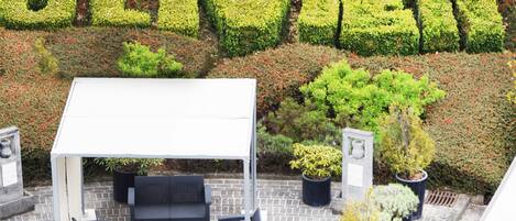 A rooftop garden with a seating area and a pergola.
