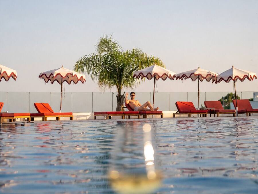 Una piscina con sillas de descanso y sombrillas.