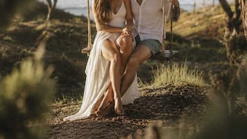 Una pareja en un columpio con un paisaje natural de fondo.