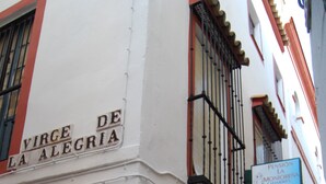 A building corner with a sign reading "Virge de La Alegria". - Pensión Montoreña (Seville)