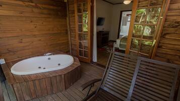 A wooden cabin with a wooden bathtub, a wooden chair, and a wooden floor.