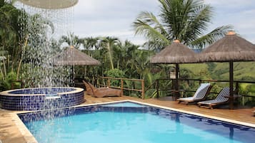 Una piscina al aire libre, camas de piscina gratis, sombrillas