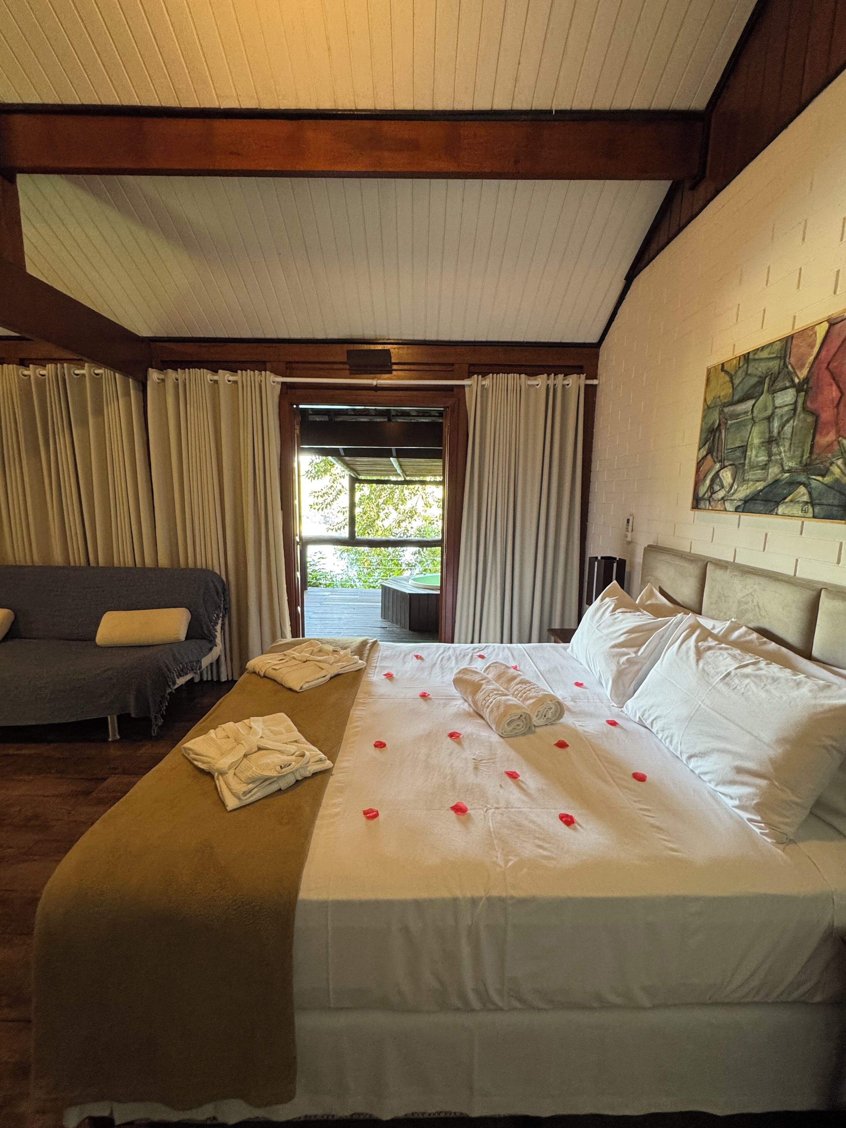 Ein Hotelzimmer mit einem Bett, einer Couch und Blick auf Grünfläche.