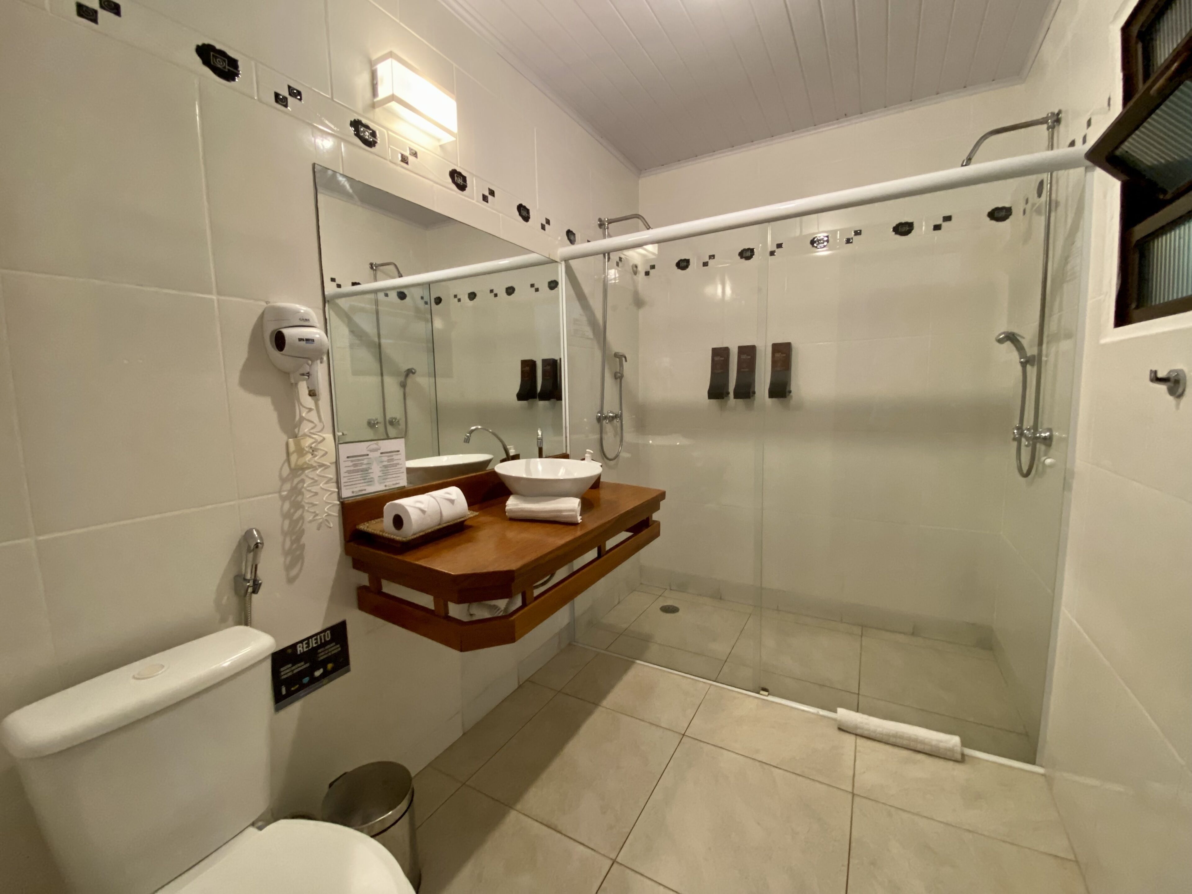 A modern bathroom with a glass-enclosed shower, a vanity with a sink, and a toilet.