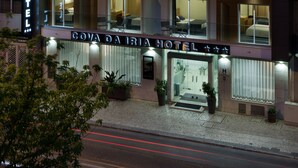 Un hotel de varios pisos con ventanas e balcones iluminados, una entrada visible y un letrero que dice "Gova da Rio Hotel".