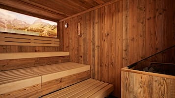 A wooden sauna with benches and a view of mountains.