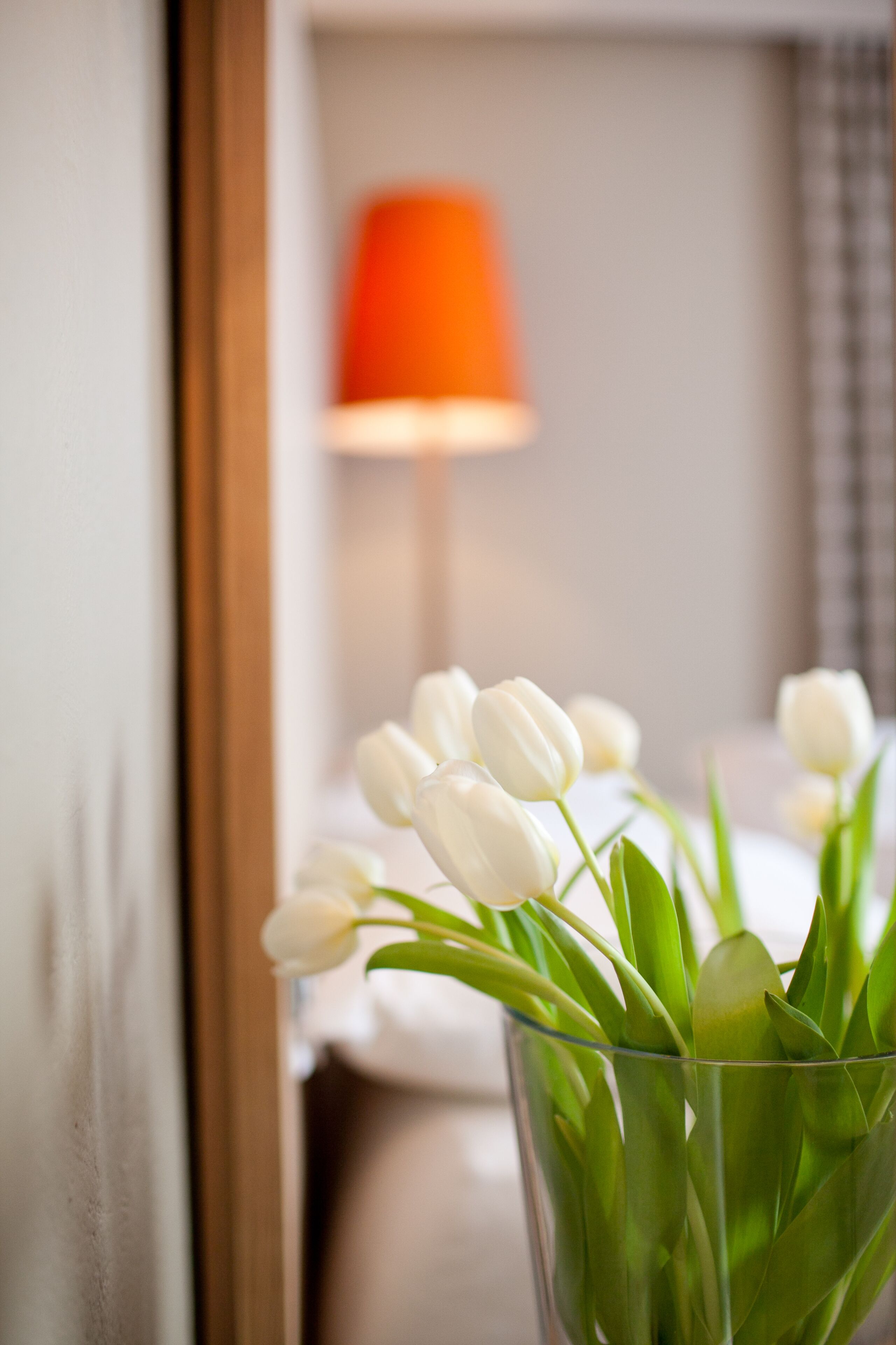 Eine klare Glasvase mit weißen Tulpen auf einem Tisch.