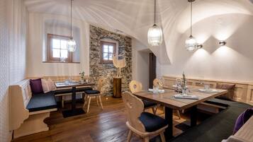 Un comedor acogedor con muebles de madera, paredes de piedra y un ambiente rústico.