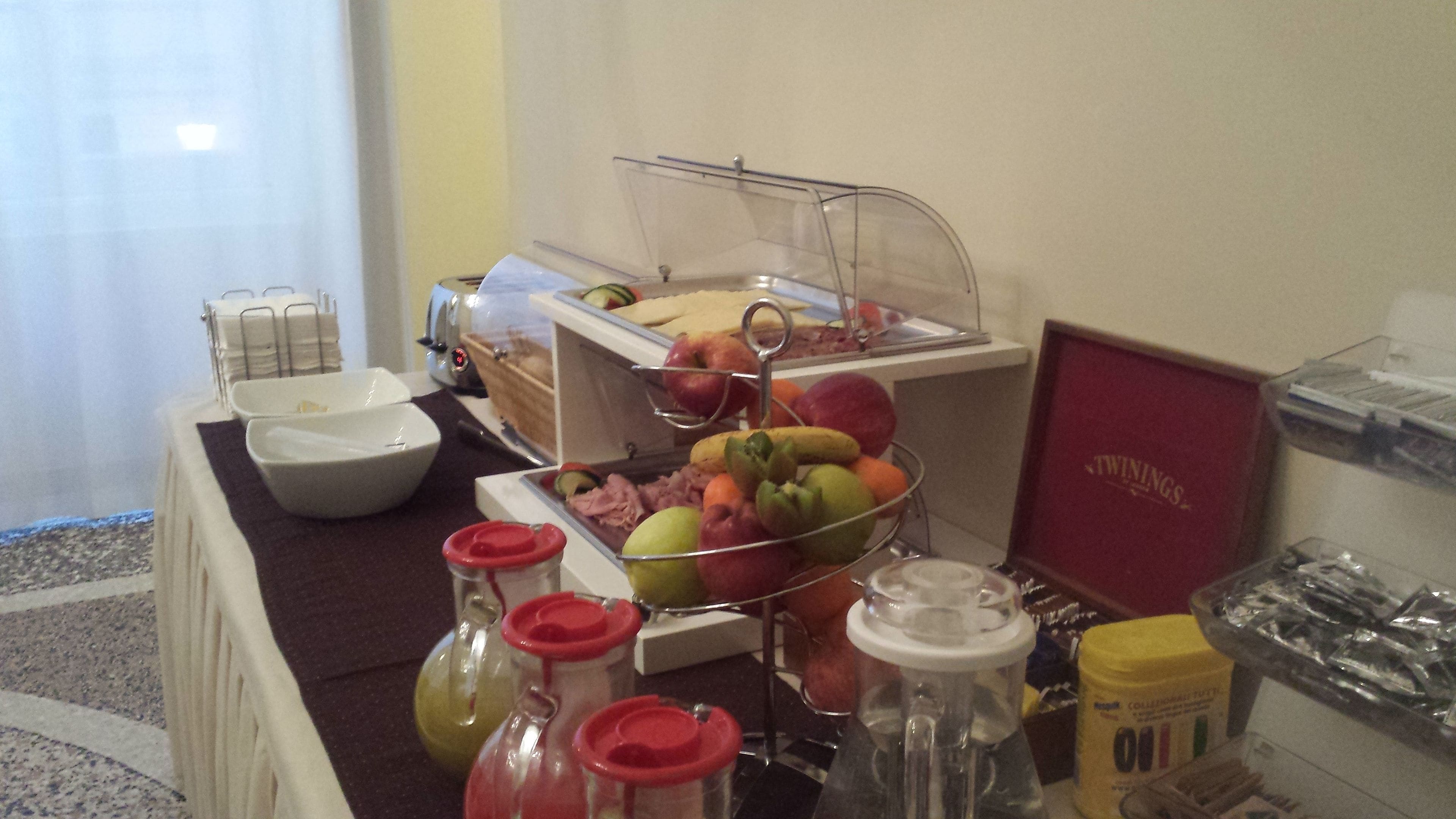A buffet setup with various food items and condiments.