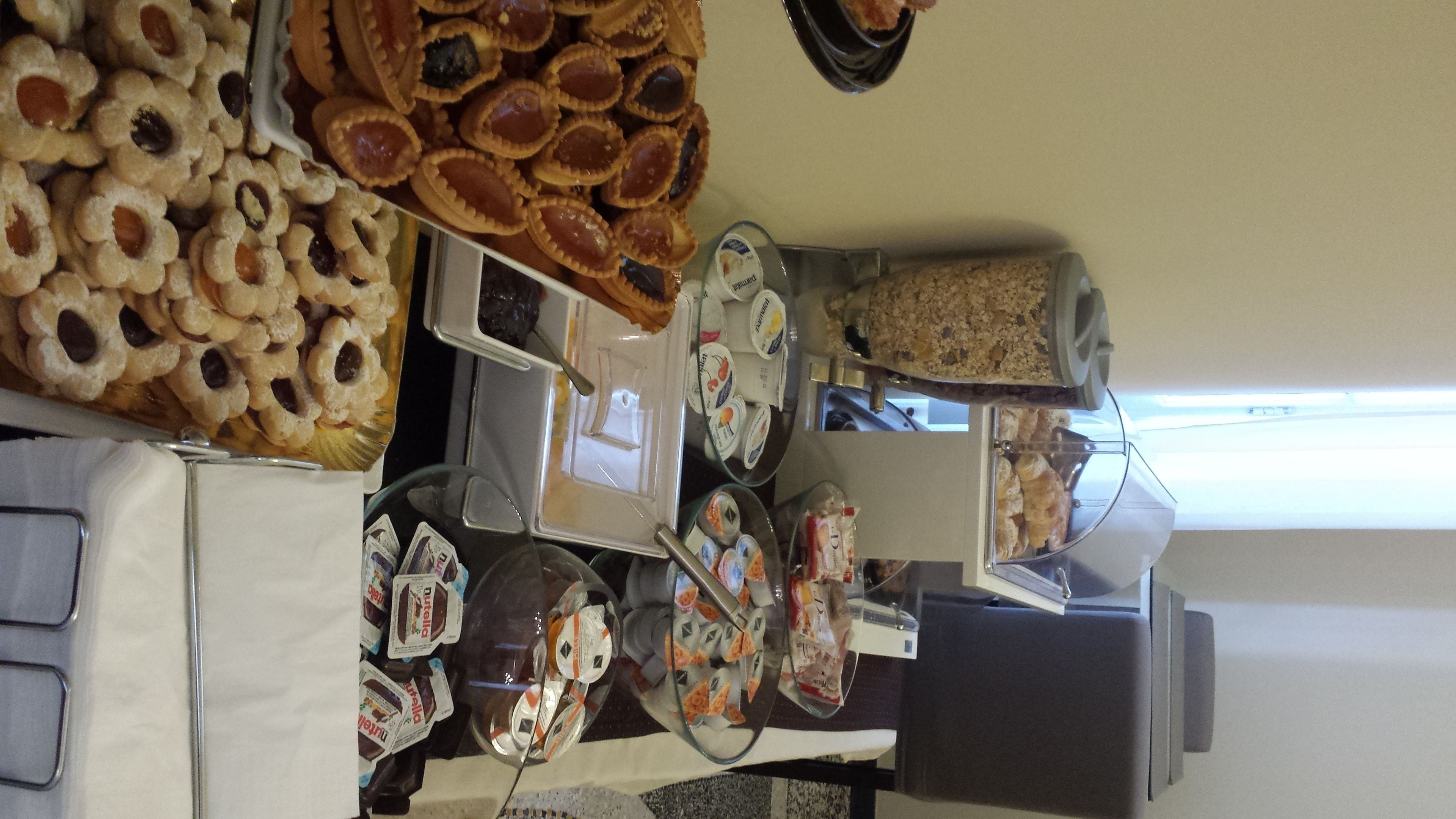 Un buffet proposant une variété de plats, notamment des pâtisseries et des desserts, disposés sur une table.