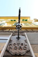 A hotel sign with the name "HOTEL NORD" and a decorative lamp post in front.