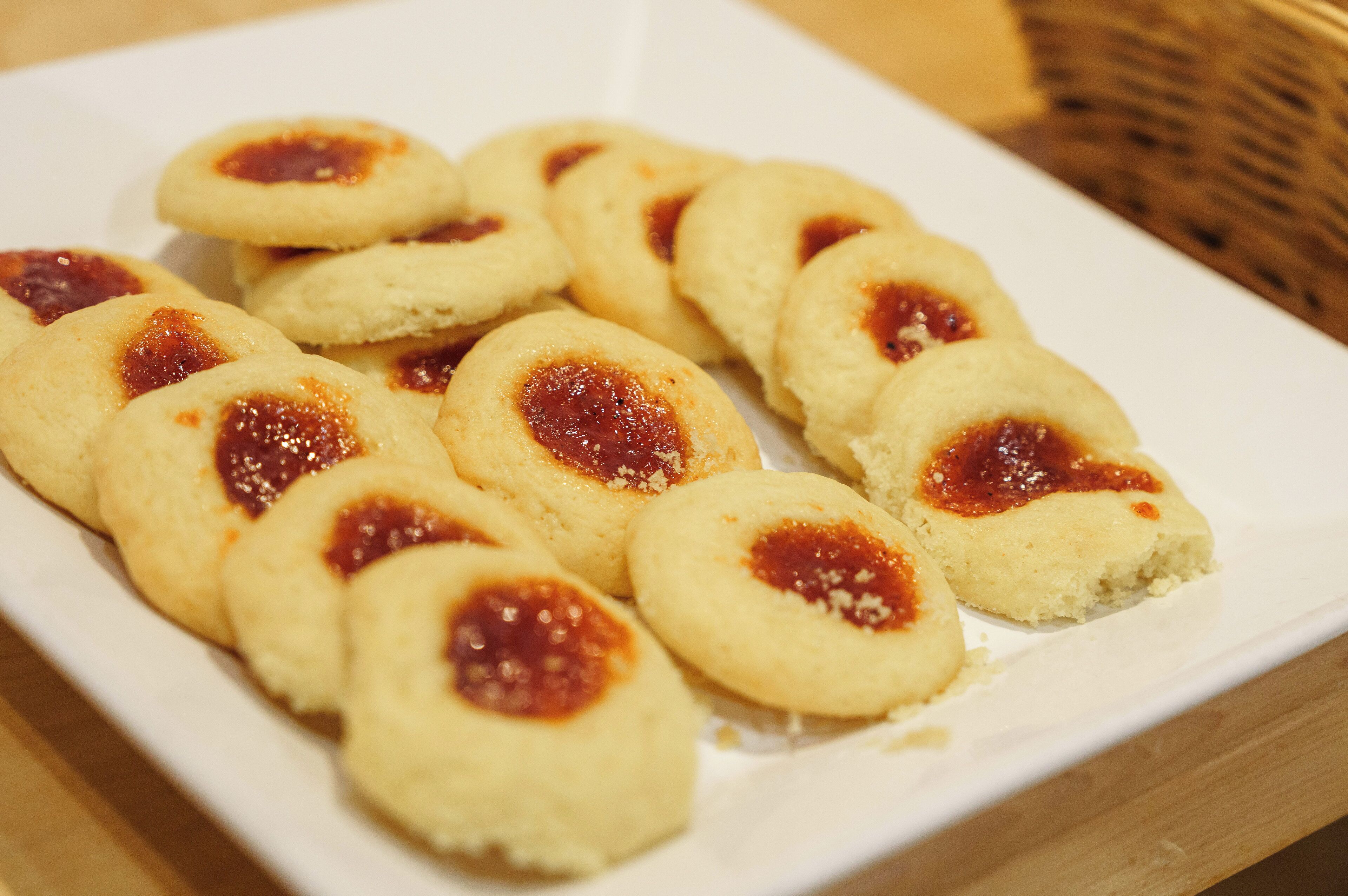 Une assiette de biscuits ronds garnis de confiture au centre.