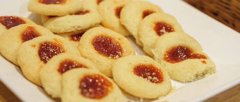 Une assiette de biscuits ronds garnis de confiture au centre.