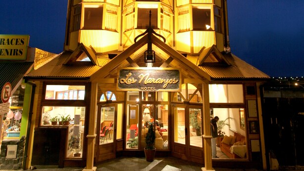 A multi-story hotel with a distinctive architectural design, featuring a central atrium and a sign reading "Los Naranjos." - Los Naranjos (Ushuaia)