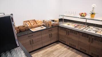 Ein Frühstücksbuffet mit Brot, Gebäck und Früchten.
