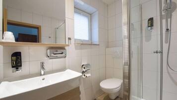 Une salle de bain moderne avec un lavabo, des toilettes et une douche à parois de verre.